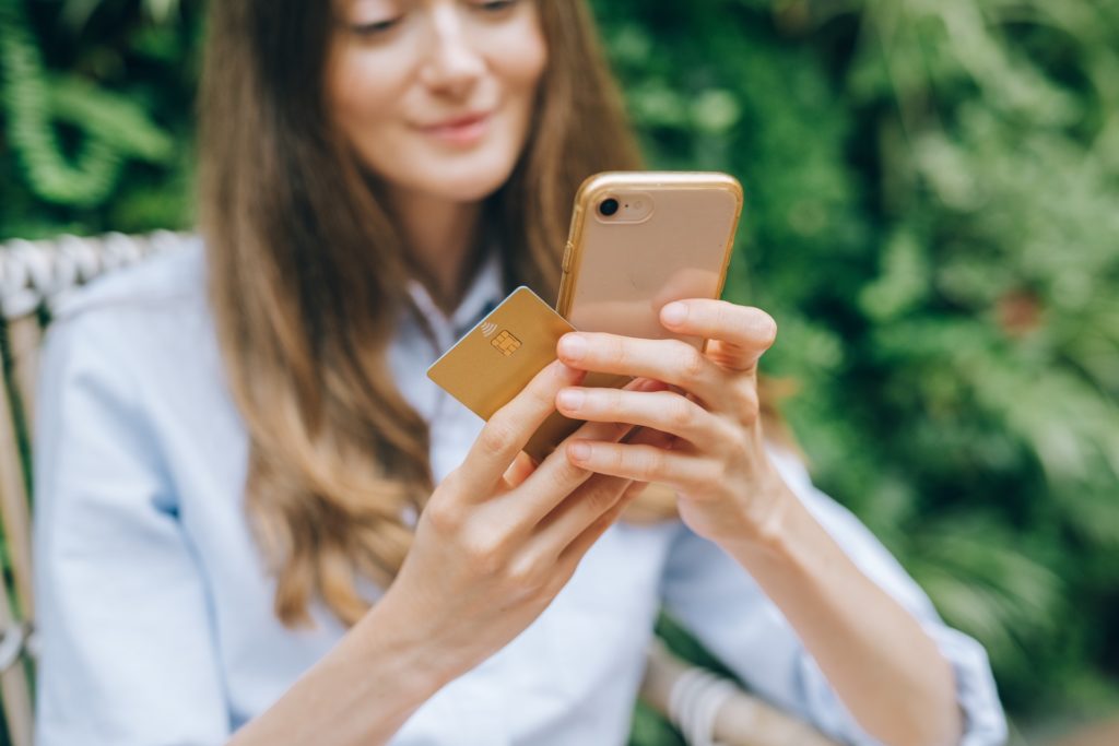 A lady holding her mobile and credit card