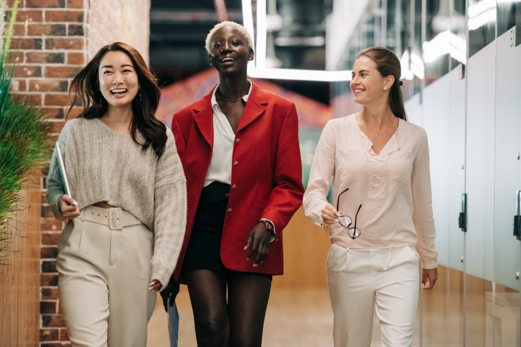 Three female workers walking down a corridor chatting