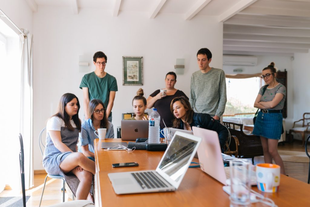 A group of employees watching a laptop screen