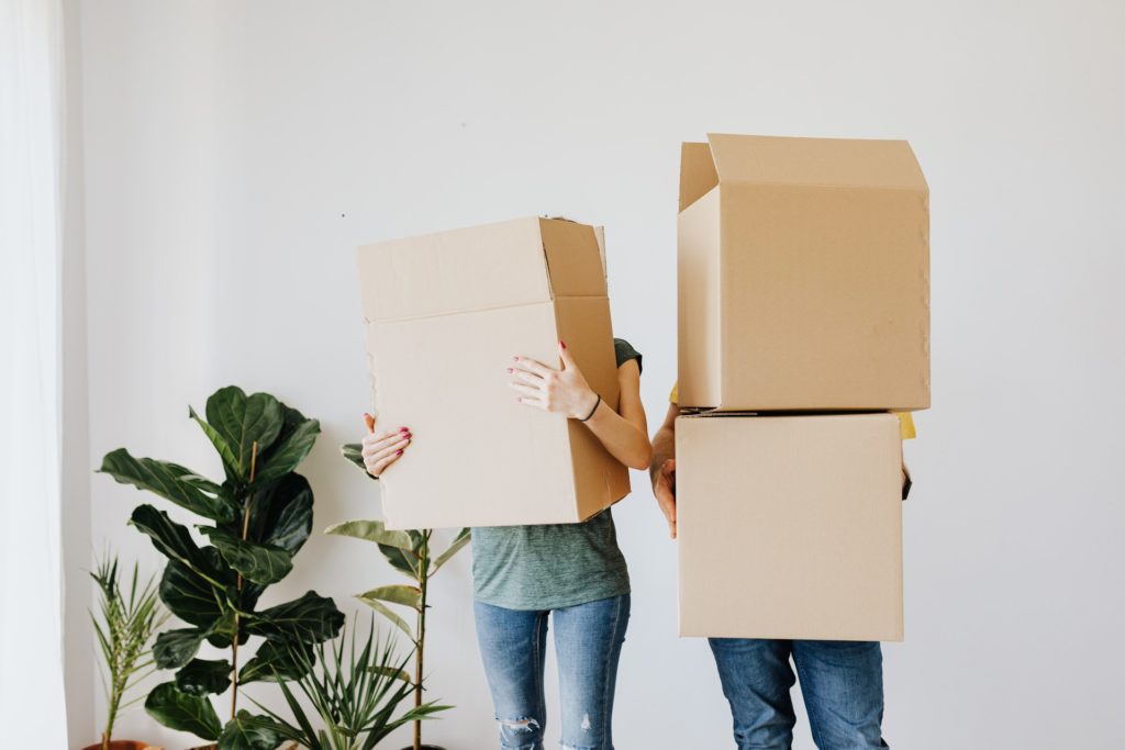 Two colleagues carrying moving boxes