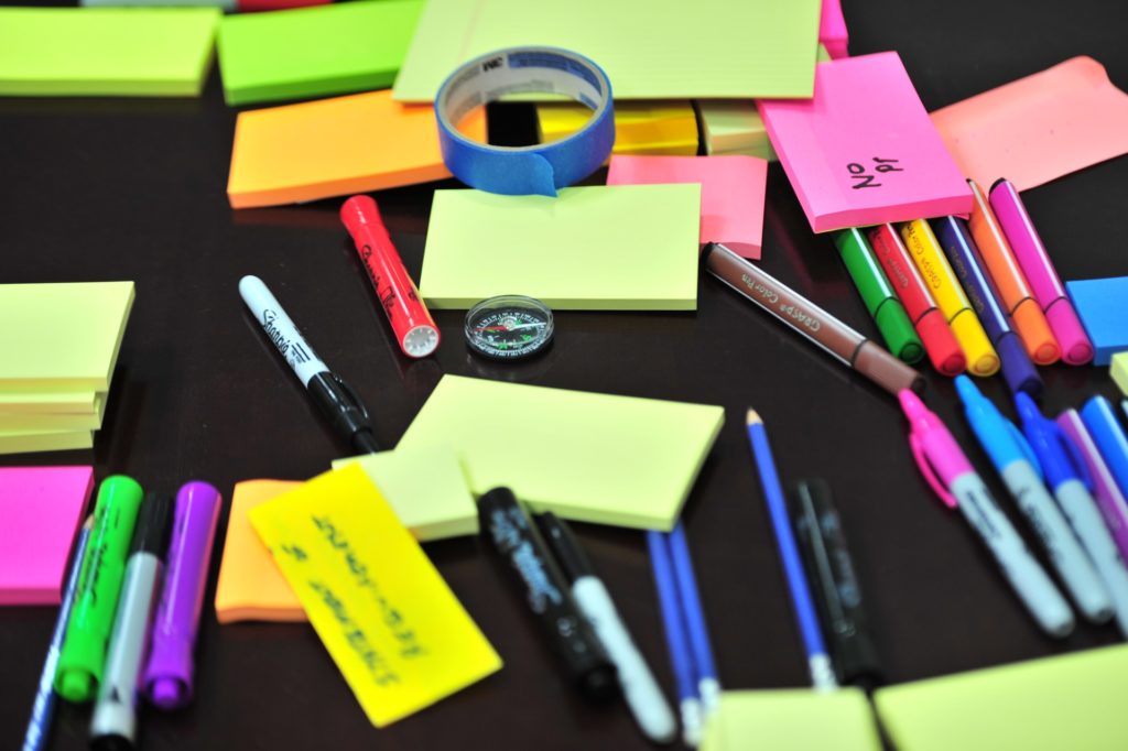 A table covered with sticky notes, pens and other stationery