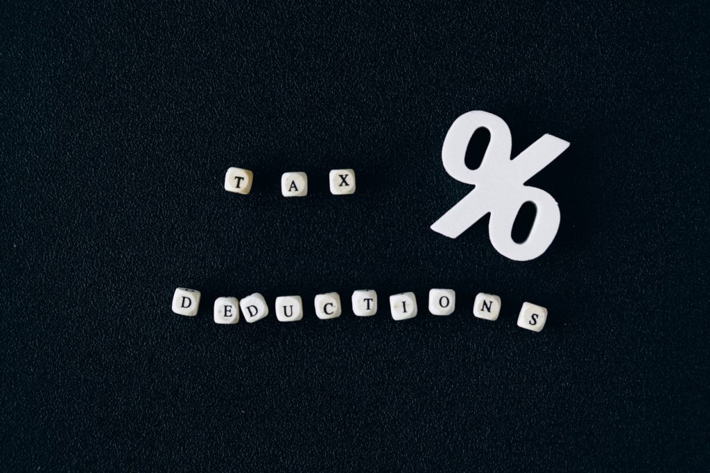 White block letters spelling "TAX DEDUCTIONS" against a black backdrop