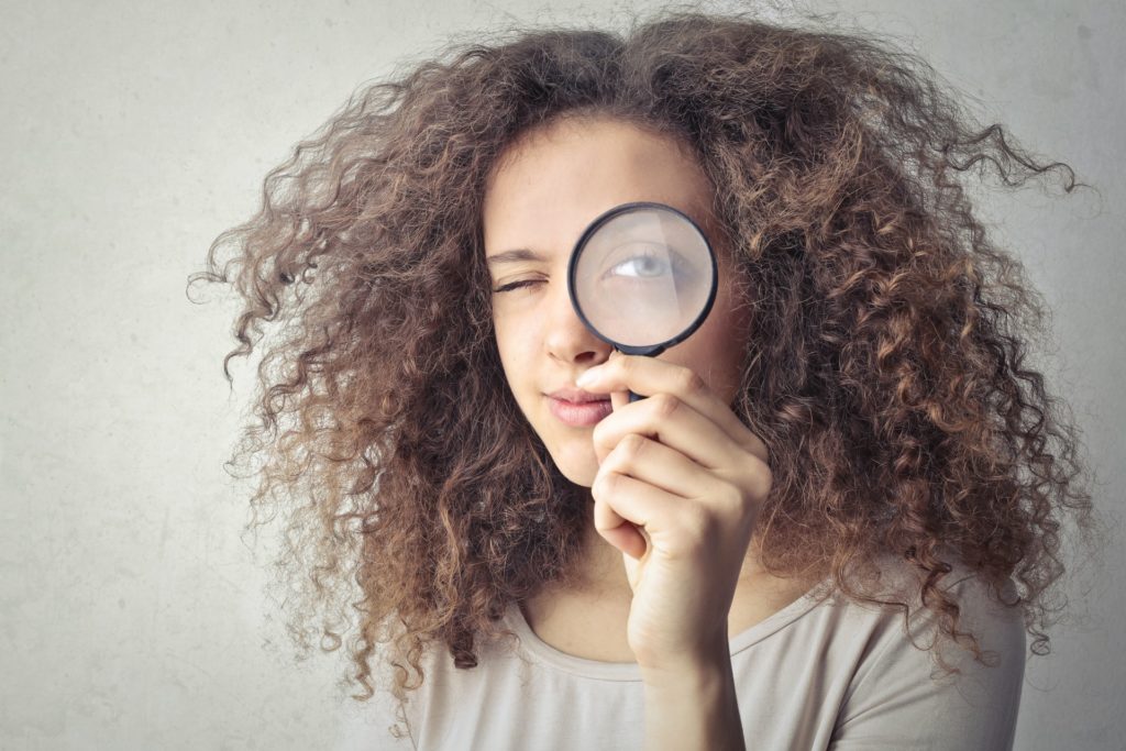 A lady looking through a magnifying glass