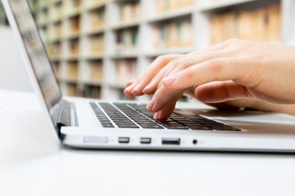 A zoomed in image of hands typing on a laptop