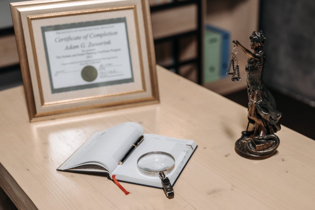 An Open Book on the Table with Magnifying Glass and a framed certificate