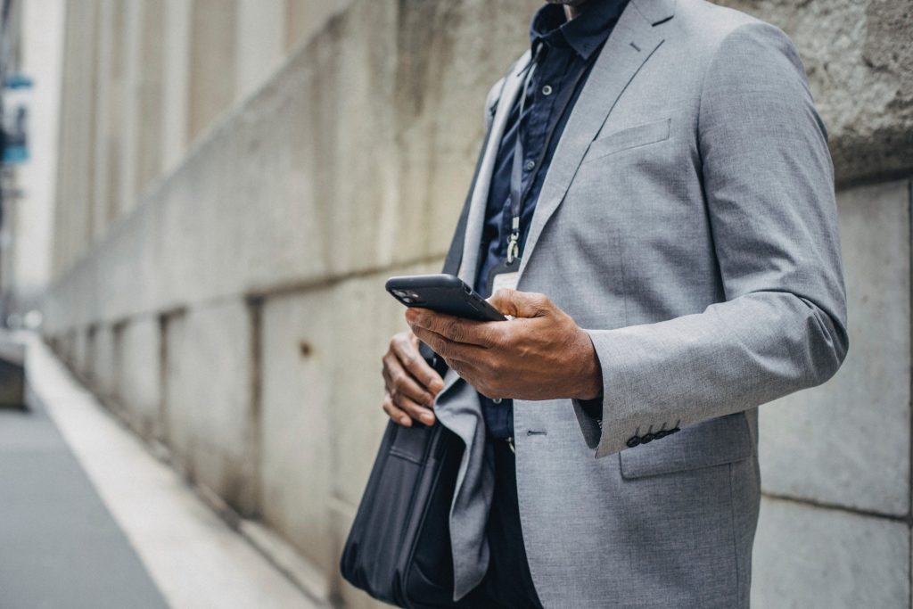 A male accountant waiting with his mobile in his hand