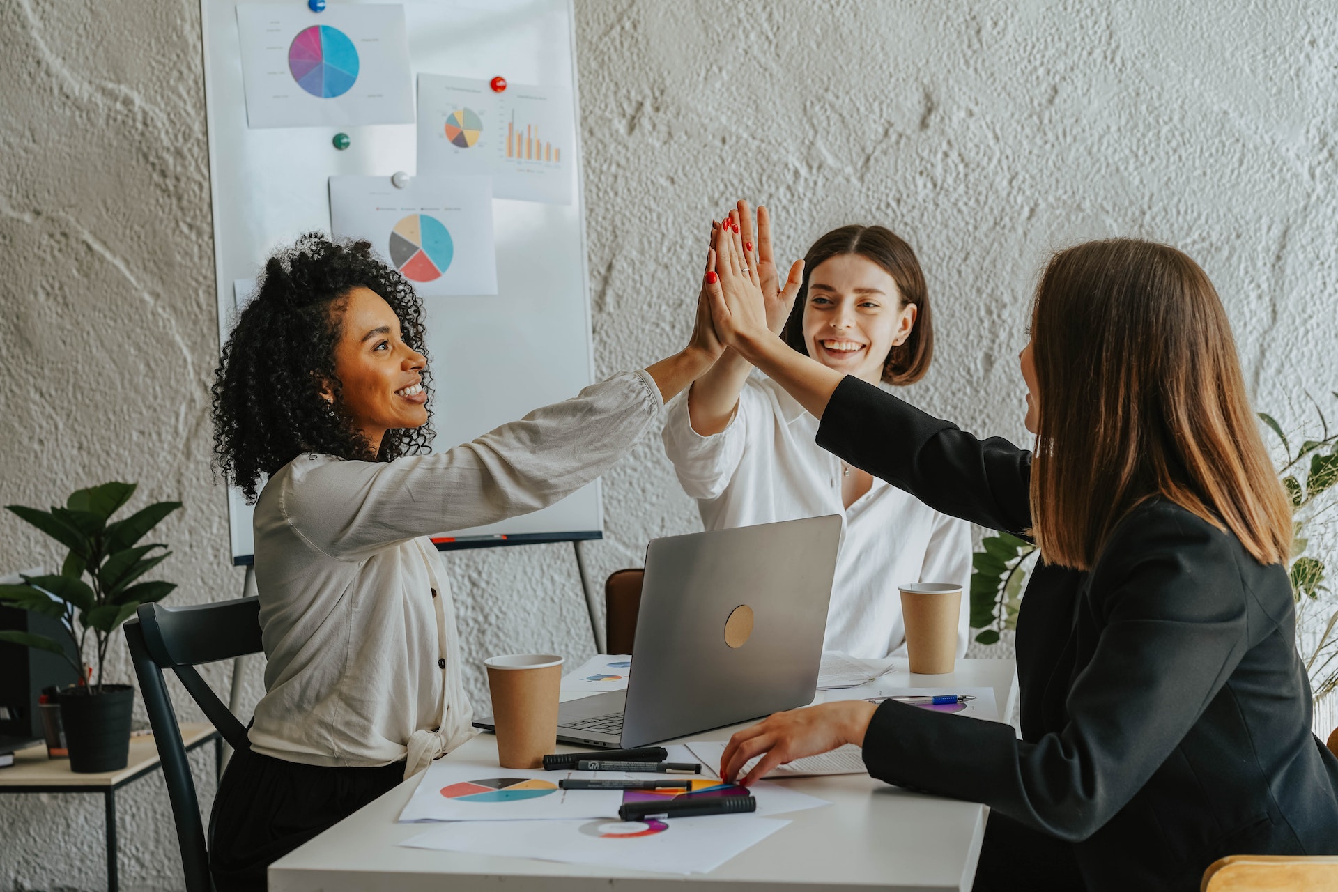 A team of female accountants high fiving