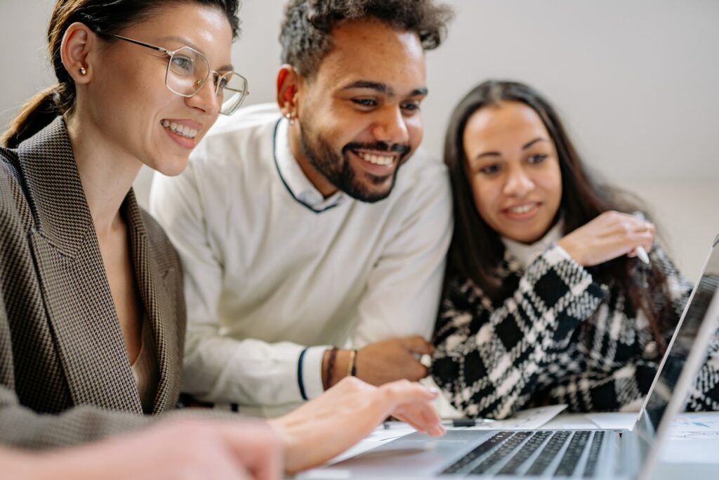 An AP team around a laptop, happy with their AP automation software