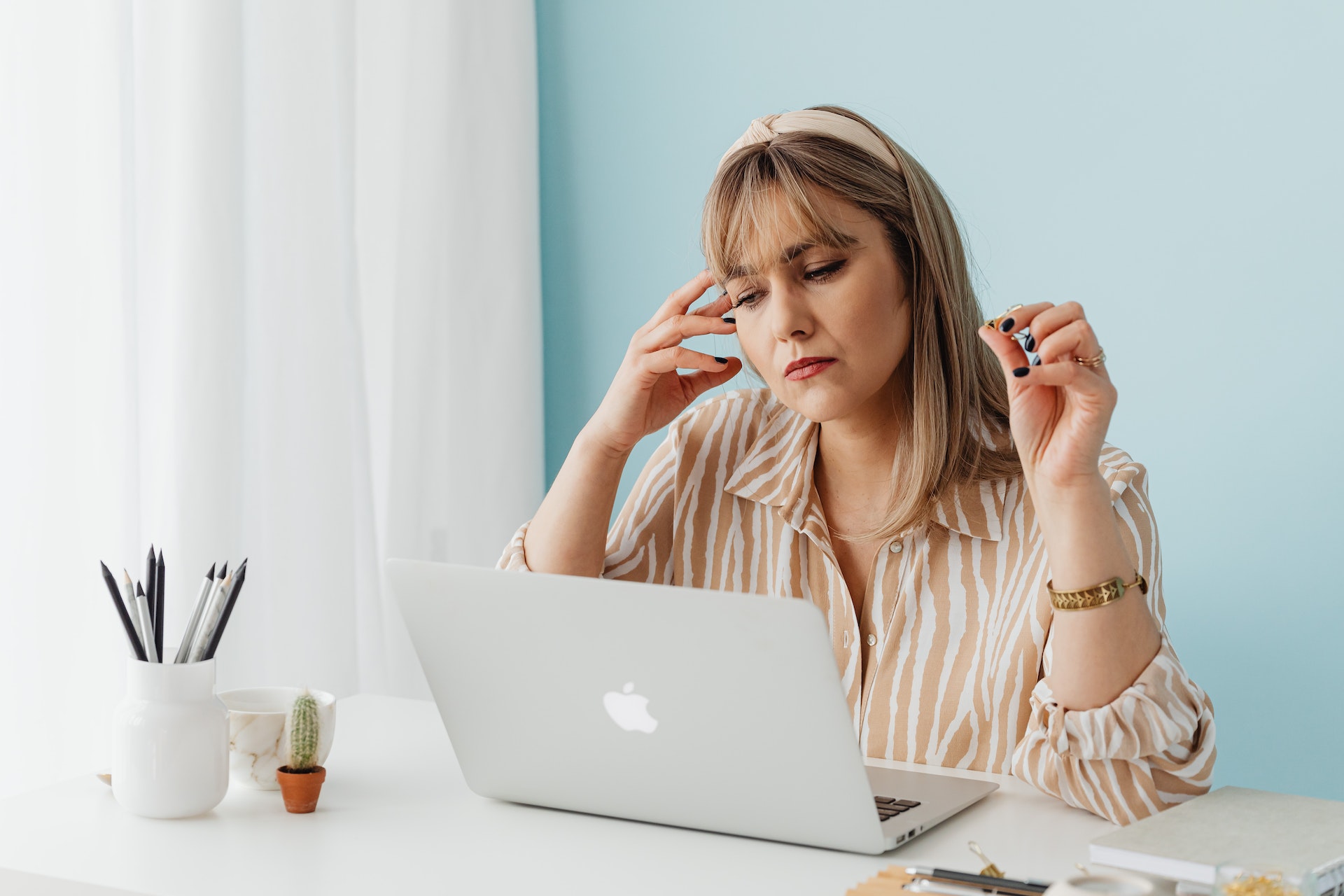 A woman sitting at her laptop thinking about how to effectively manage her AP