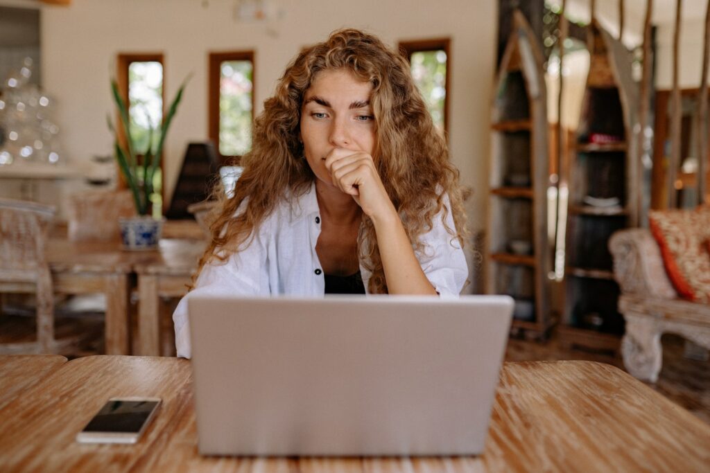 a lady thinking at her laptop