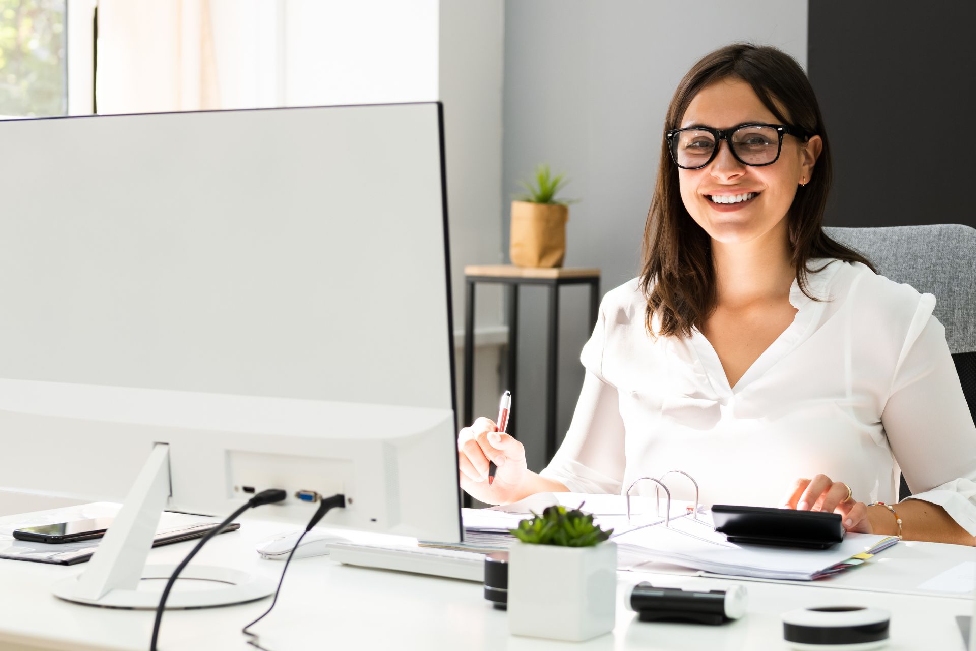 employee smiling in front of a computer