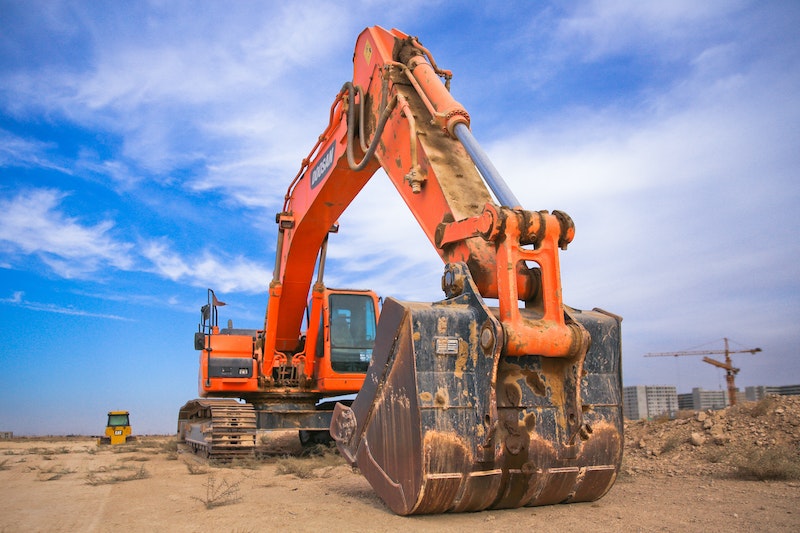 orange excavator in land