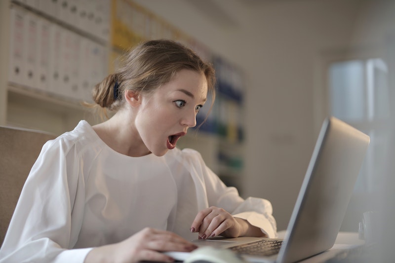 woman surprised looking at her silver laptop