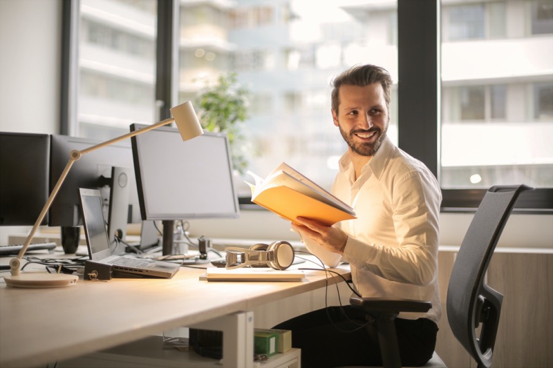 sitting in front of a working table smiling