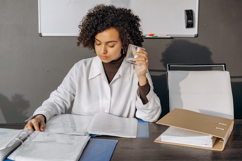 woman holding glass reading