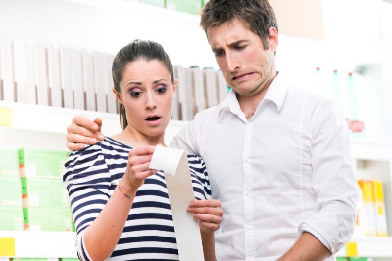 woman looking at a receipt surprised