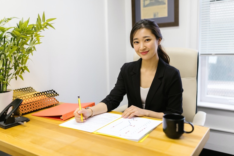 woman writing in a paper at work smiling