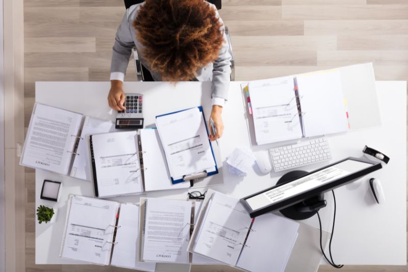 businesswoman computing invoices in the office