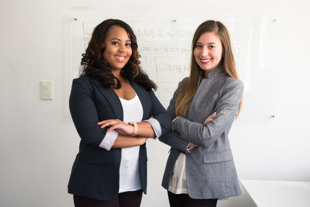 two confident women smiling