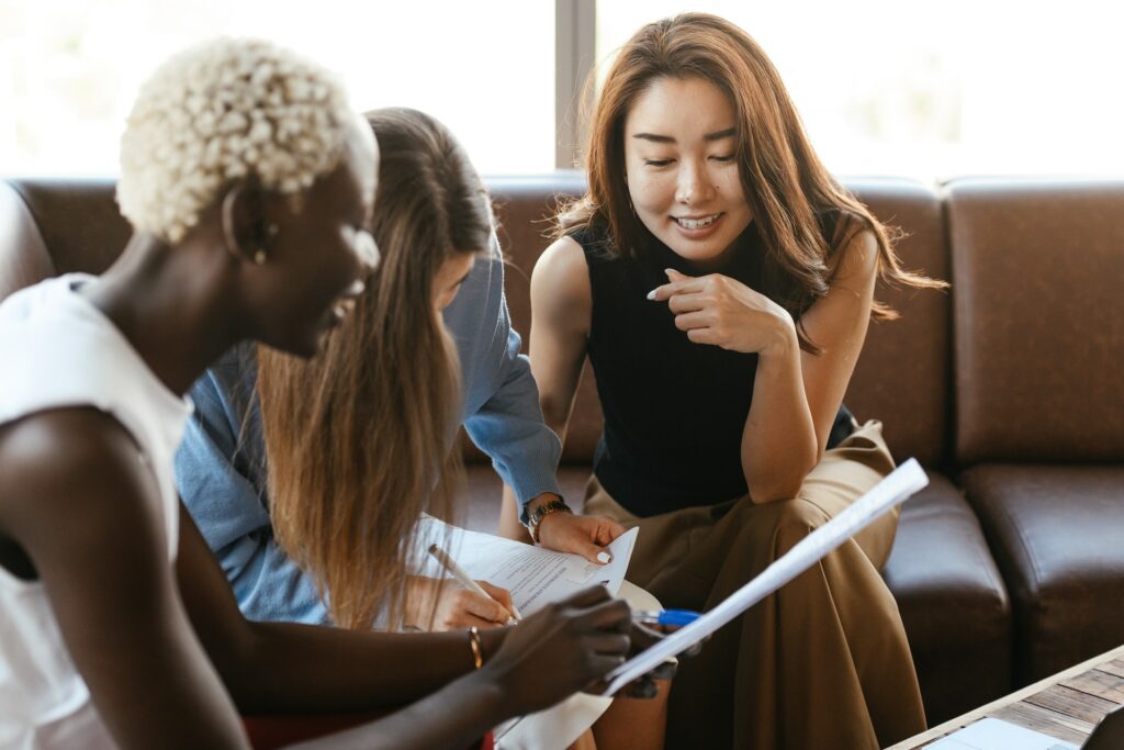 multiethnic-cheerful-colleagues-talking-about-job-and-working-with-documents