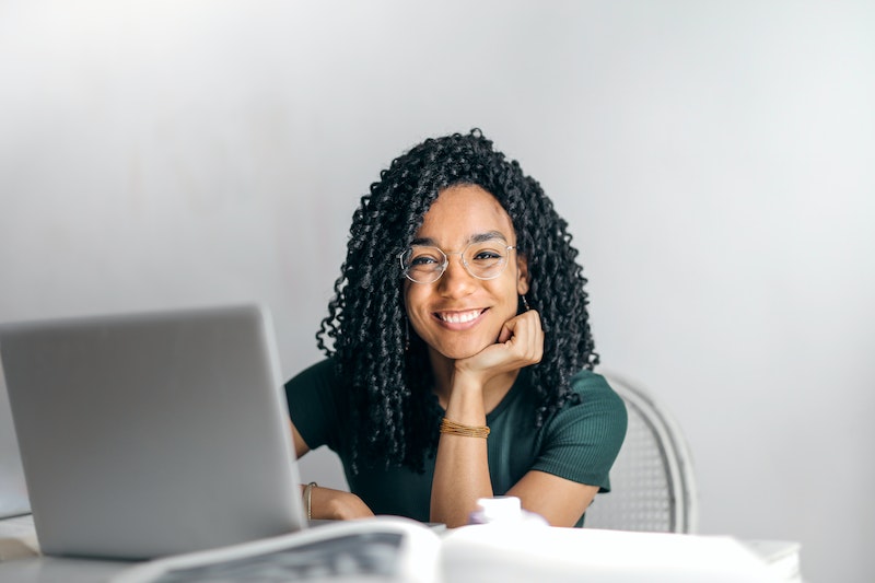 woman smiling in front of a laptop