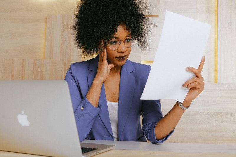 woman in blue blazer holding a paper