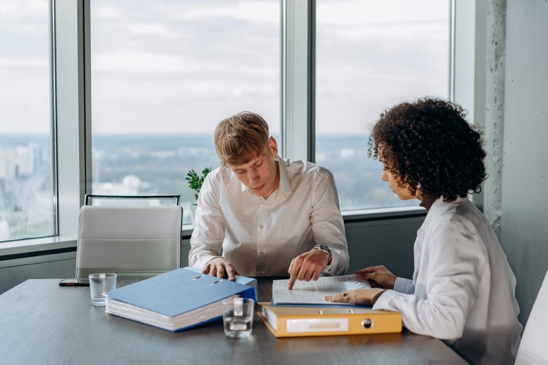 man teaching his officemate about work