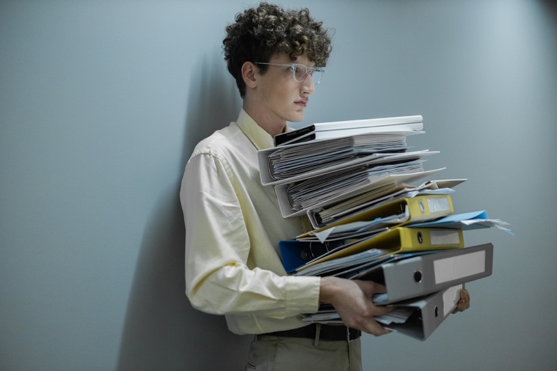 man holding stack file