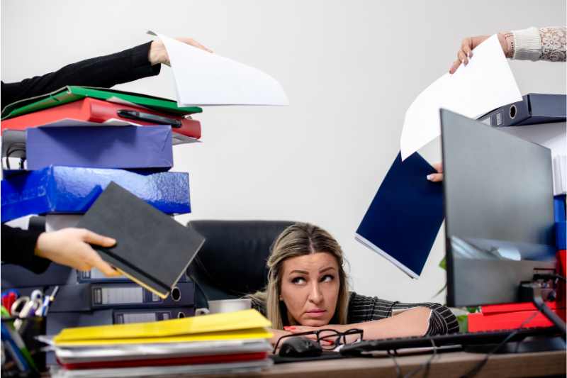 Woman under stress from excessive paper work