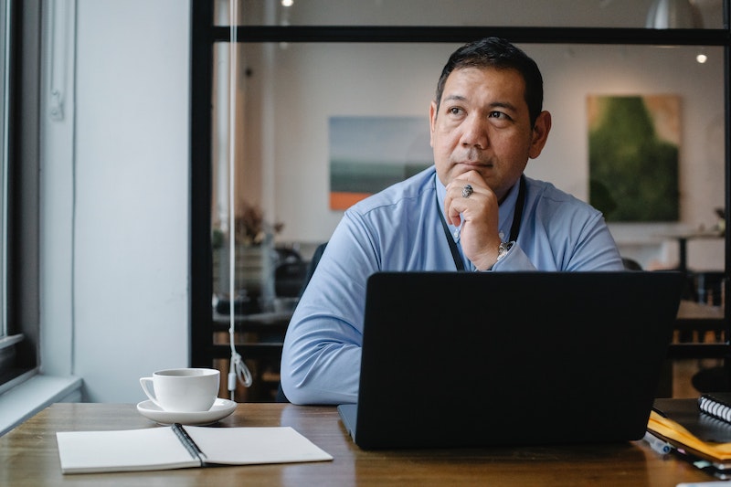 pensive man in front of a laptop