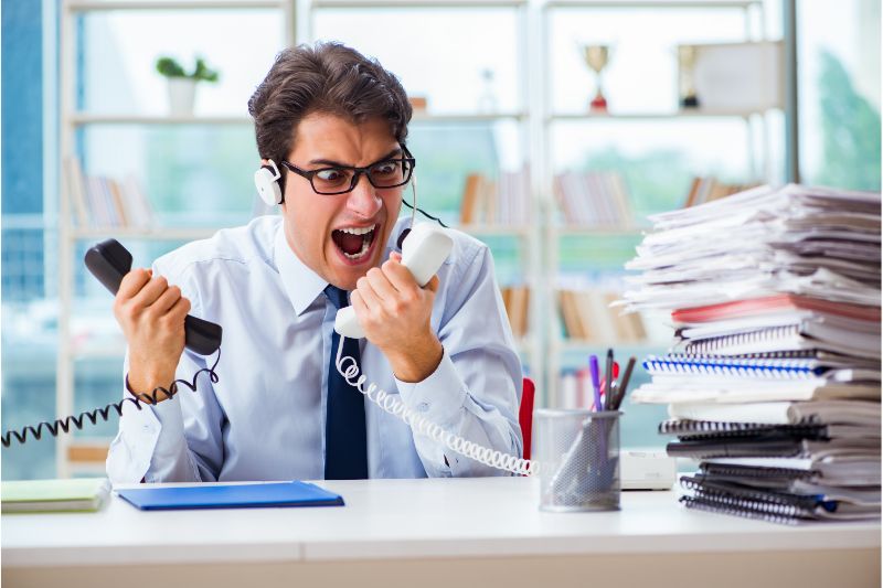 angry business man screaming at phone in his office