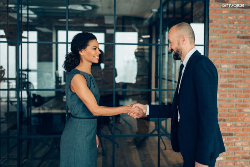 Business professionals sealing a deal, reflecting trust-driven benefits of automated invoice processing.